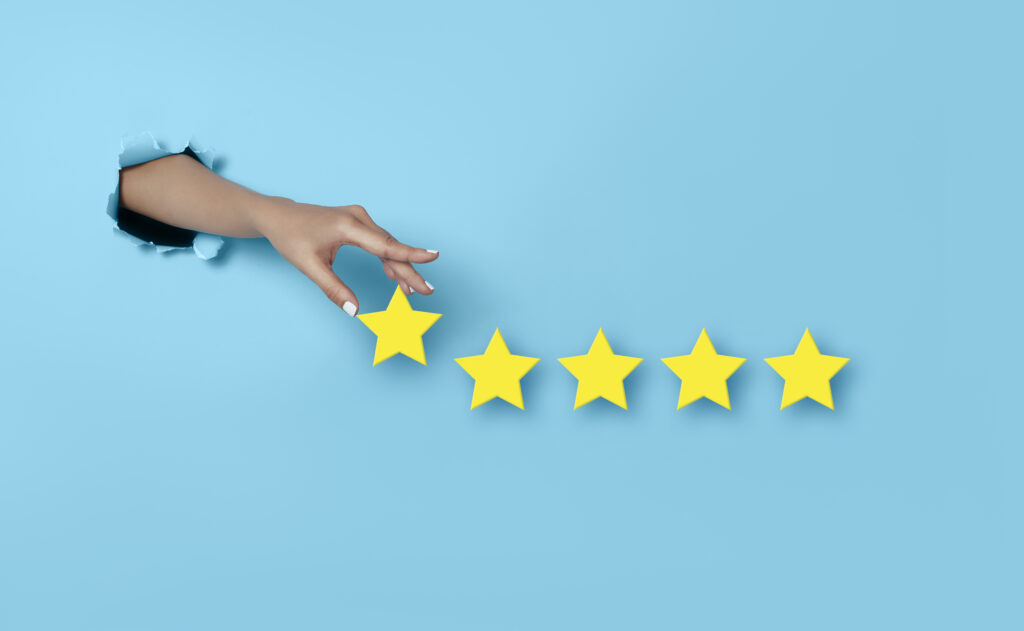 Strategia di local marketing e stelline di recensione gialle lasciate dalla mano di un cliente su sfondo azzurro