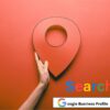 mano che mostra il segnalino rosso di ricerca di Google maps e sotto con una barra di ricerca di Google con su scritto Google Business Profile